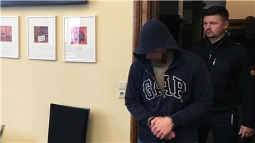 Mann wird in Gerichtssaal geführt. 