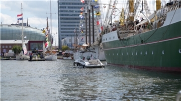 Ein Boot fährt auf der Sail 2025 in Bremerhaven entlang der "Alex II".