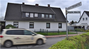 Ein Auto fährt an Häusern vorbei