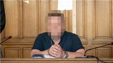 Ein Mann sitzt auf der Anklagebank eines Gerichts. 