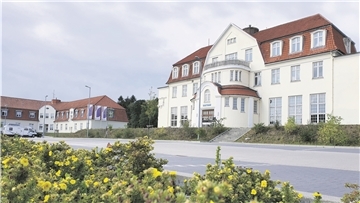 Er ist der architektonische Glanzpunkt im ansonsten nüchternen Nordholz – der Jugendstil-Komplex am Feuerweg: Im zentralen Gebäude (links) gäbe es auf rund 3000 Quadratmetern viel Platz für das erste „Regionale Versorgungszentrum“ in Niedersachsen.