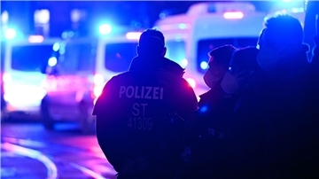 Polizisten vor Einsatzfahrzeugen