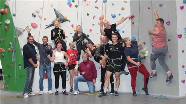 Eine Gruppe von Menschen an einer Kletterwand.
