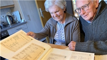 Erinnerungen an über 40 Jahre Milchbar: Horst und Margot Biwald - beide Mitte 80 - blättern in den alten Bildern aus der Eröffnungszeit 1957 bis zum Ruhestand im Mai 1998. Hier amüsierter Blick auf die Original-Karte von 1957: Ein Glas Milch 20 Pfennige. Ein Flip (mit Eigelb) „Lustige Witwe“: 2 D-Mark.