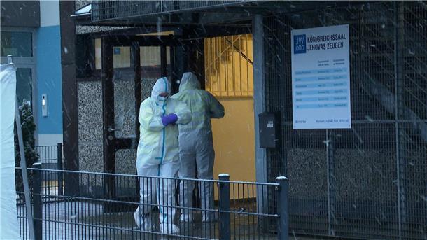 Tödliche Schüsse in Hamburg: Was wir wissen - und was nicht Ermittler stehen am Morgen vor dem Gebäude der Zeugen Jehovas in Hamburg, in dem mehrere Menschen getötet wurden.