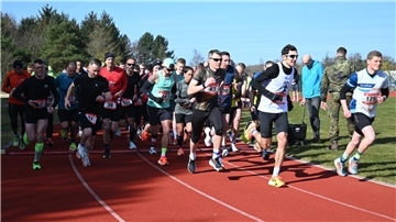 Ein Gruppe läuft über ein Sportfeld. 