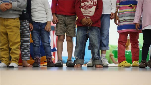 Kinder stehen in einem Kindergarten. 