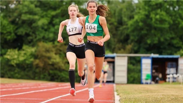 Zwei Leichtathletinnen umrunden die Bahn.