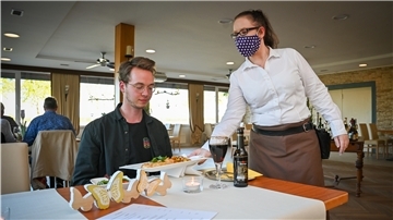 Essen zum Testen in Corona-Zeiten: Volontär Jannik Sauer wird im Restaurant zur Mühle in Sievern von Monique Hildebrandt bedient.