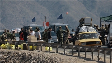 Ethnische Armenier aus Berg-Karabach und Beobachter der Europäischen Union fahren mit ihren Autos an einem Kontrollpunkt auf der Straße von Berg-Karabach nach Goris vorbei.