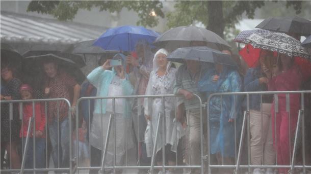 Bayreuther Festspiele mit Blitz und Donner eröffnet Etliche Schaulustige trotzen dem Wetter, um die Auffahrt der Prominenz zu beobachten.