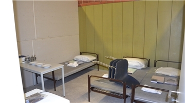 Etwa 15 Quadratmeter misst ein Dreibettzimmer in der Flüchtlingsunterkunft. Es verfügt über Betten, Stühle, Geschirr, Spinde, einen Tisch und einen Kühlschrank. 