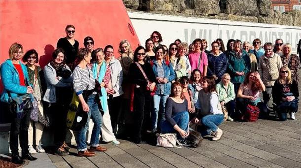 Etwa 40 Frauen stehen vor einem Leuchtturm vor dem Zoo am Meer in Bremerhaven.