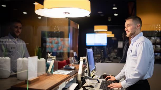 Ein junger Mann arbeitet an der Rezeption eines Hotels