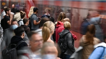 Fahrgäste warten an einem Gleis im Tiefbahnhof des Frankfurter Hauptbahnhofs, während eine S-Bahn einfährt.
