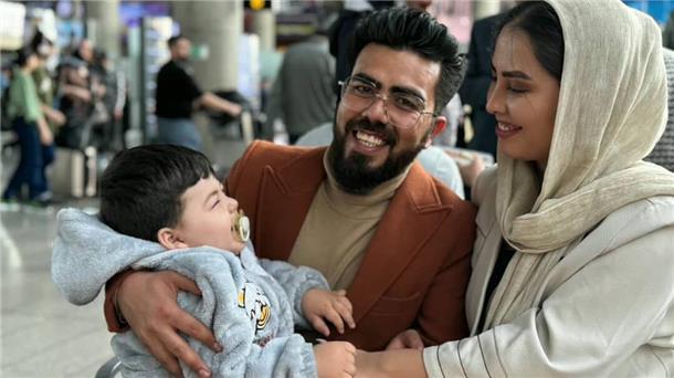 Eine Familie – bestehend aus einem jungen Mann, einer jungen Frau und einem kleinen Kind – sieht glücklich aus. Alle lachen.