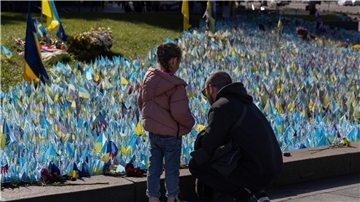 Familienmitglieder besuchen in Kiew das Denkmal für ukrainische Soldaten, die im Krieg gegen Russland gefallen sind.