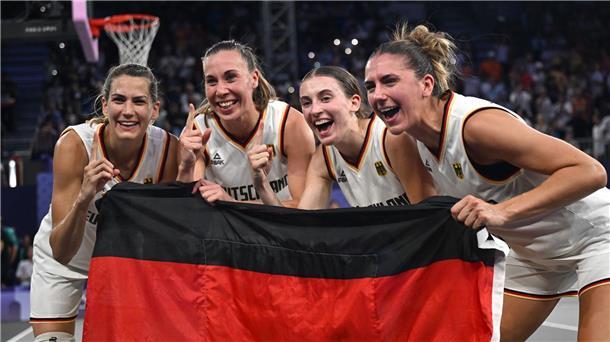 Olympiasieg und Umarmung mit Nowitzki: Gold für 3x3-Damen Feiern mit der Fahne: Die 3x3-Basketballerinnen.