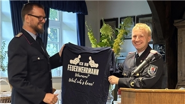 Lobesworte und Präsente für verdienten Feuerwehrmann Abschnittsleiter Henning Herzig überraschte Torben Henning mit einem T-Shirt.