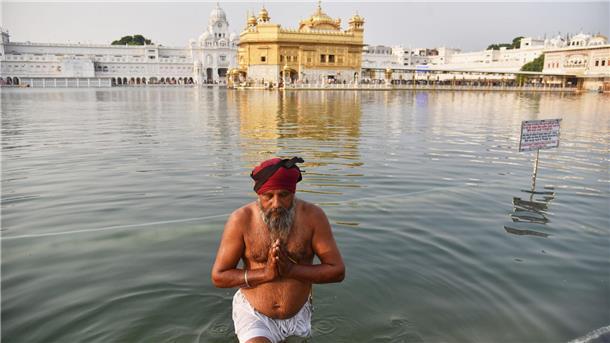 Feiertag Guru Nanak Jayanti: Sikh-Anhänger nimmt ein heiliges Bad im Goldenen Tempel.