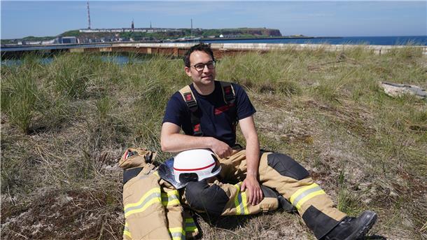 Felix Vorndran von der Freiwilligen Feuerwehr Bergisch-Gladbach sitzt an der Feuerwehrwache während seines Dünendienstes auf der Düne der Hochseeinsel Helgoland.