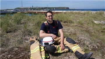 Felix Vorndran von der Freiwilligen Feuerwehr Bergisch-Gladbach sitzt an der Feuerwehrwache während seines Dünendienstes auf der Düne der Hochseeinsel Helgoland.