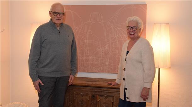 Ferdinand und Ilona Rogge aus Zeven daheim an einer Grafik mit Häusern der Andacht der Bahá'i, die es weltweit gibt. Eines davon steht in Langenhain bei Frankfurt am Main.