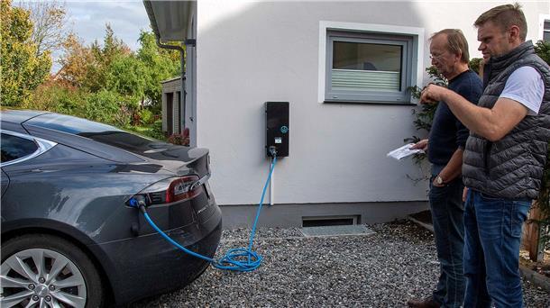 Ferienhausbesitzer Heiko Dahl und Till Brömmer testen die neue „Zapfsäule“ für Elektroautos in Wremen.