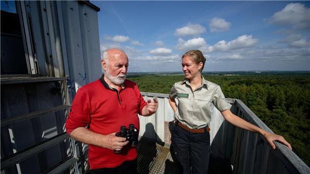 Feuerwächter Rudolf Hoffmann im Gespräch mit Försterin Carla Paul auf dem Feuerwachturm Galgenberg in Nordrhein-Westfalen.