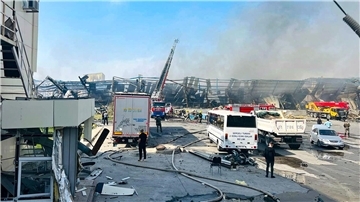 Feuerwehrleute arbeiten nach einer Explosion daran, einen Brand in einer Lagerhalle  zu löschen.