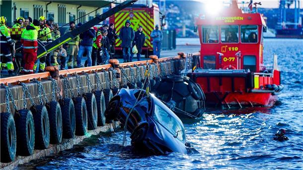 Auto landet in Fjord - Schwimmende Sauna kommt zur Rettung Feuerwehrleute bergen das versunkene Auto aus dem Fjord.