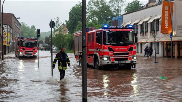 Feuerwehrleute bewegen sich durch das Hochwasser in Saarbrücken.