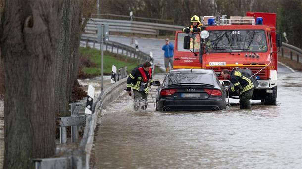 Feuerwehrleute der Freiwilligen Feuerwehr Heuchelheim ziehen einen Audi aus dem Wasser.