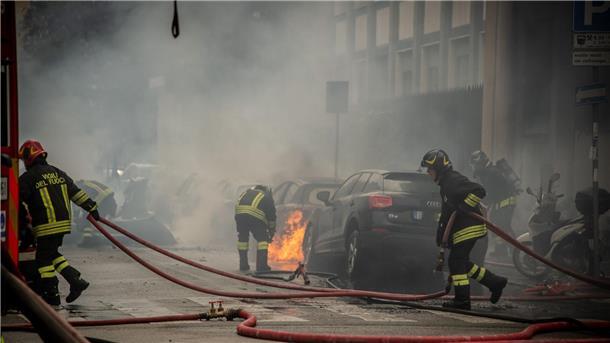 Explosionen in Mailand - Fahrzeuge brennen Feuerwehrleute löschen brennende Fahrzeuge.
