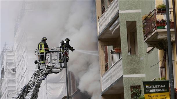 Explosionen in Mailand - Fahrzeuge brennen Feuerwehrleute Löschen einen Brand an einer Wohnung.