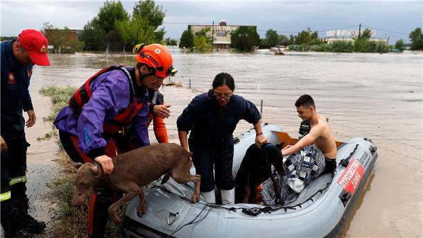 Entspannung nach Hochwasser in Bulgarien Feuerwehrleute mit einem Schlauchboot evakuieren Menschen und ihre Hunde aus überfluteten Gebäuden.