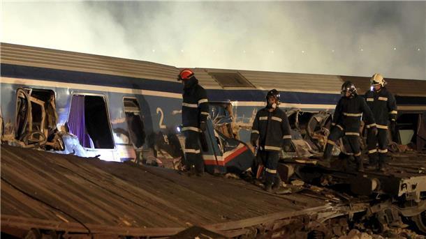 Viele Tote nach Zug-Zusammenstoß in Griechenland Feuerwehrleute nach der Kollision zweier Züge in Griechenland am Unfallort.