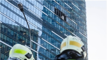 Feuerwehrleute stehen neben dem beschädigten Hochhaus im Geschäftsviertel Moskwa City.