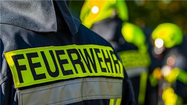 Bagger beschädigt Gasleitung: Kindergarten evakuiert Feuerwehrleute stehen zusammen, um den Einsatz zu besprechen.
