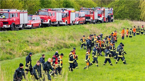 Feuerwehrleute und Polizisten suchen auf einem Feld nach der vermissten Arian.
