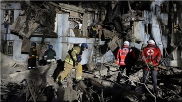 Feuerwehrleute vor einem beschädigten Haus nach dem mutmaßlich russischen Raketenangriff in Saporischschja.
