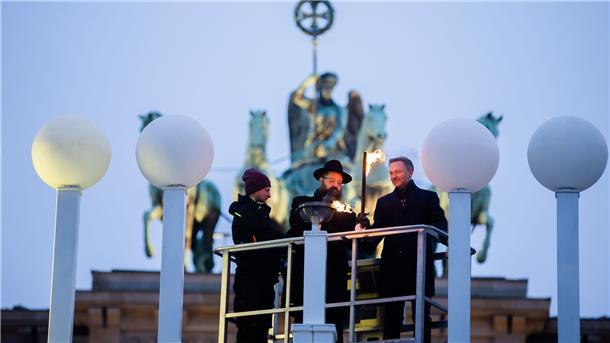 Finanzminister Christian Lindner und Rabbiner Yehuda Teichtal, Vorsitzender des Chabad Jüdischen Bildungszentrums, entzünden das erste Licht am Chanukka-Leuchter vor dem Brandenburger Tor in Berlin.
