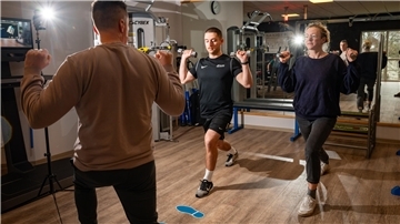 Fitnessstudio-Leiter Andreas Dullweber (links) und Trainer Fabio Hausmann zeigen NZ-Reporterin Leandra Hanke, welche Übungen gut sind, um den Weihnachtsspeck wieder loszuwerden.