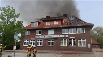 Flammen schlagen aus dem Dachstuhl der Grundschule Schwei. Die Ursache für das Feuer ist bislang unbekannt.