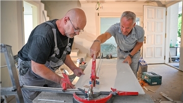 Fliesenleger Rainer Schönenborn (rechts) und sein Geselle Tadeus Popow vermuten, dass Handwerker ihren Kunden die gesetzlichen Regeln zur Mehrwertsteuersenkung erklären müssen.