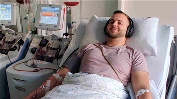 Ein Mann liegt in einem Krankenhausbett und ist an ein Gerät angeschlossen.