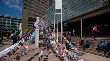 Fotos von Klägern hängen vor einem Gericht in Den Haag, in dem ein Klimaprozess gegen den Öl- und Erdgaskonzern Shell stattfindet (Archivbild).
