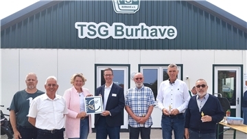 Mehrere Frauen und Männer stehen vor dem neuen Vereinsheim der TSG Burhave. Dieses wurde am Sonnabend offiziell eingeweiht.