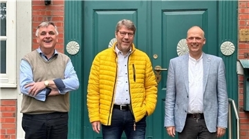 Freuen sich über die gelungene Renovierung der Türen am Pfarrhaus: Uwe Schradick als Leiter des Vorstandsstabs der Zevener Volksbank (Mitte) sowie die Pastoren Markus Stamme (rechts) und Manfred Thoden.