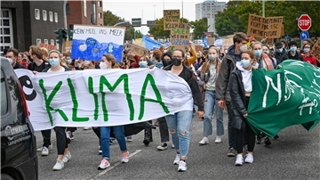 Junge Menschen demonstrieren mit Plakaten